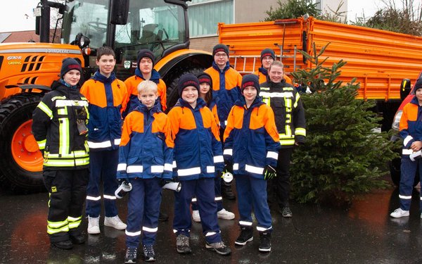 Gruppenfoto, der einiger Jugendlicher mit Tannebaum und Trecker